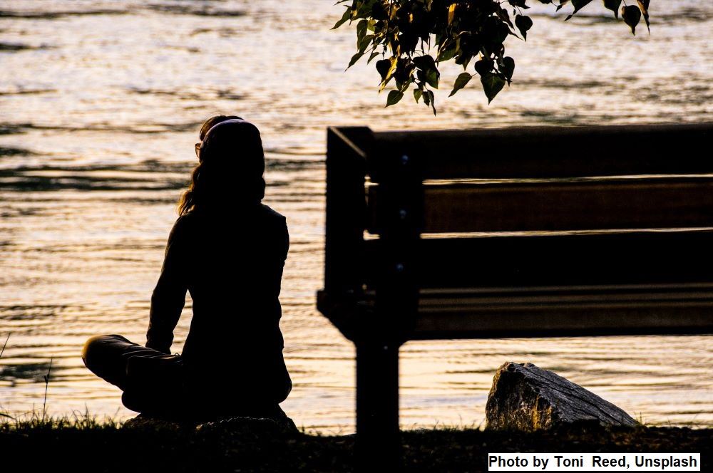 Woman lost in contemplation by a lake